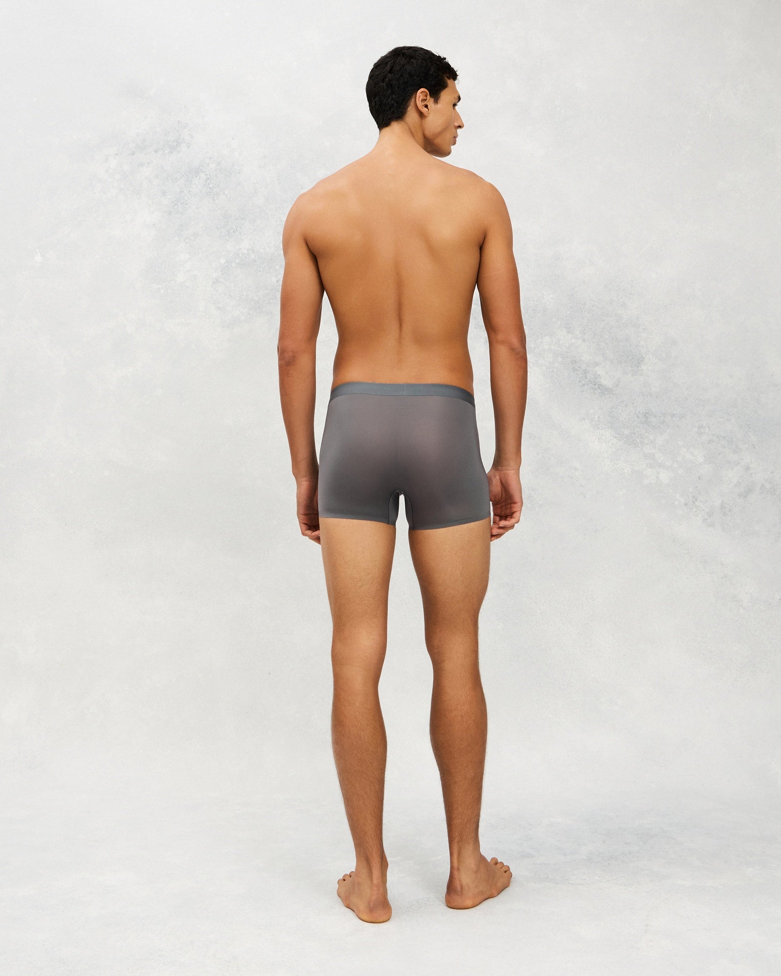 Back photo for a Model wearing Ultra Light Ice Tech Trunk in dark grey.