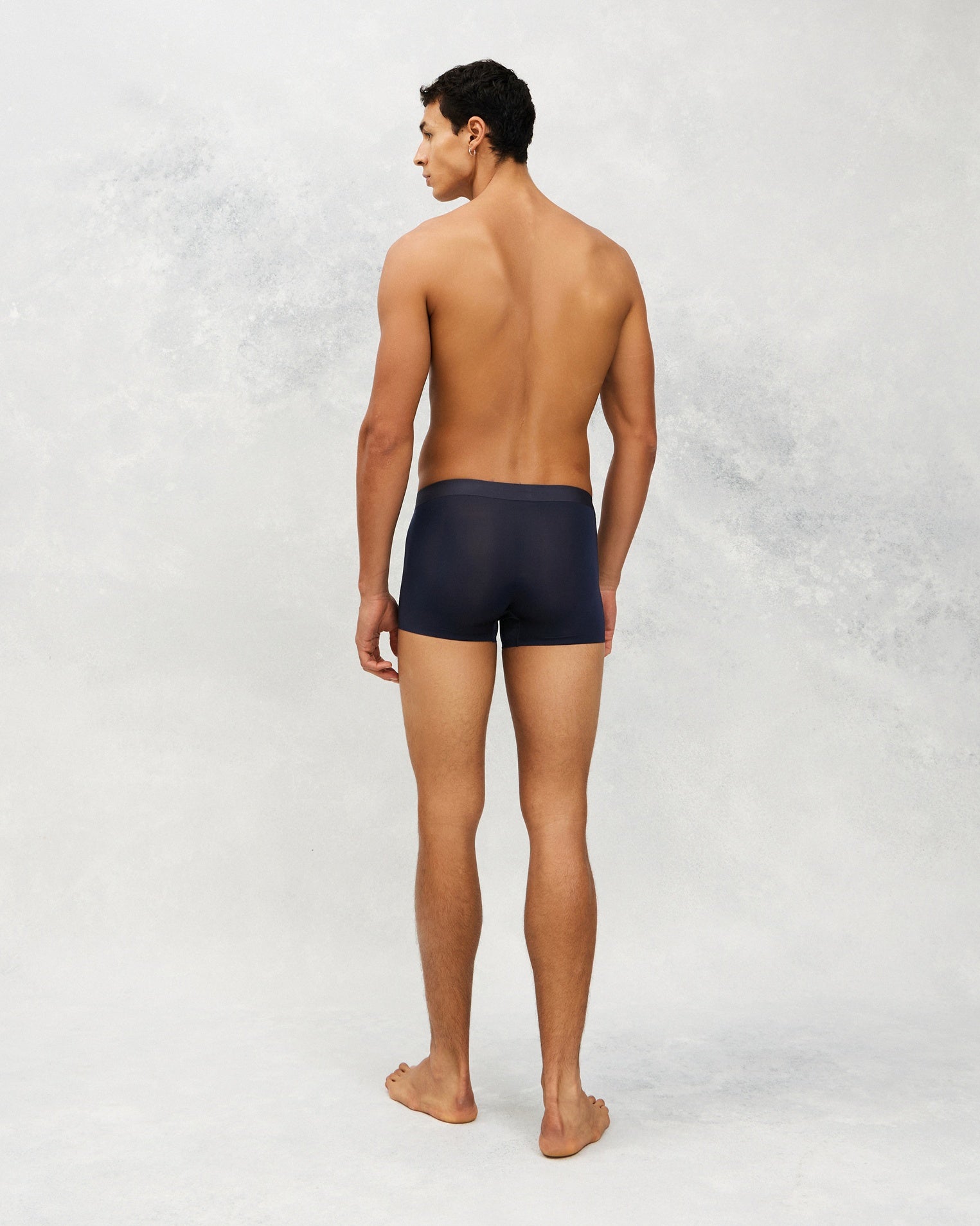 Back photo for a Model wearing Ultra Light Ice Tech Trunk in dark blue.