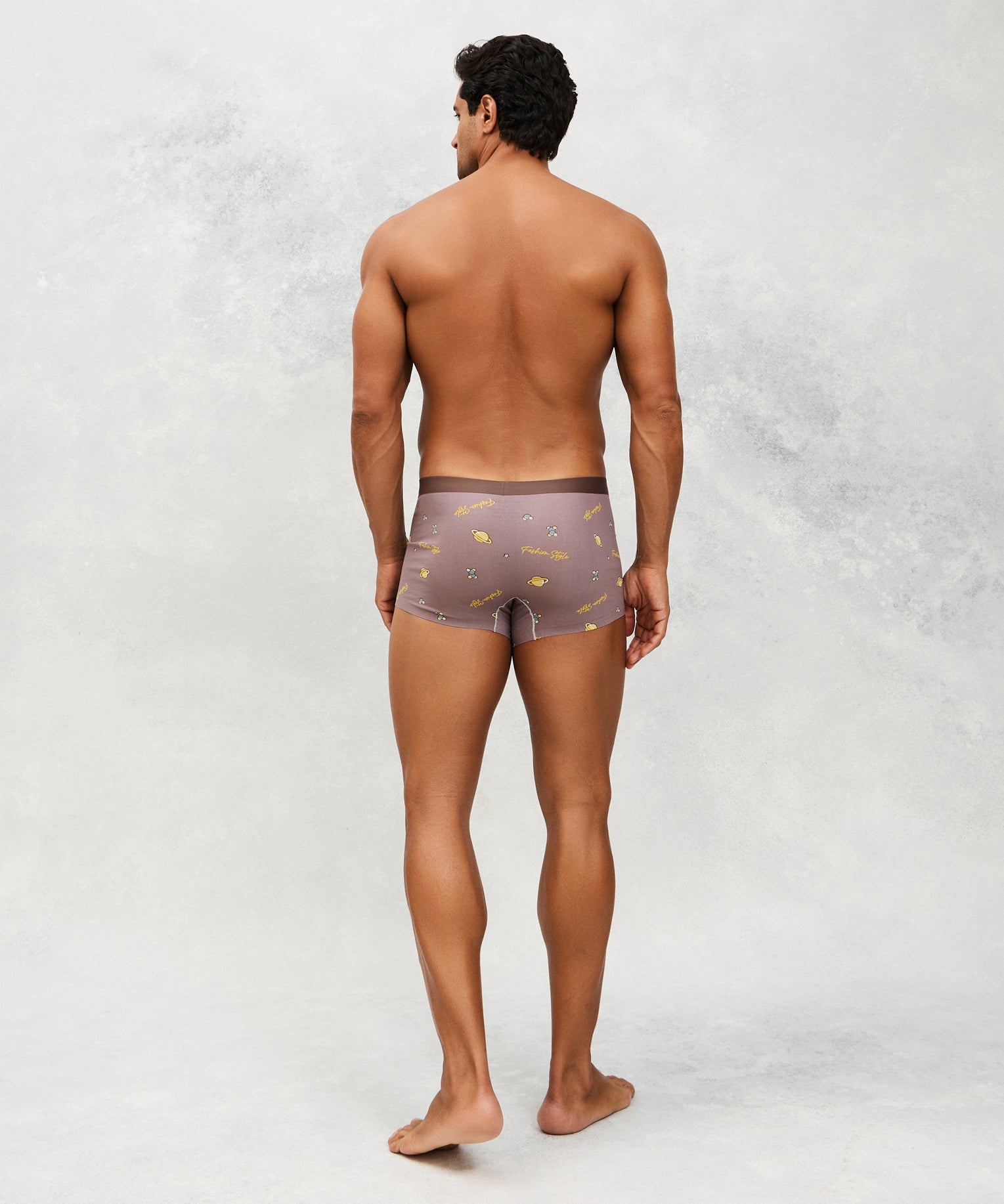 Back photo for a model wearing CottoSilk Galaxy Cotton Trunk in Brown with smooth finish and space print.