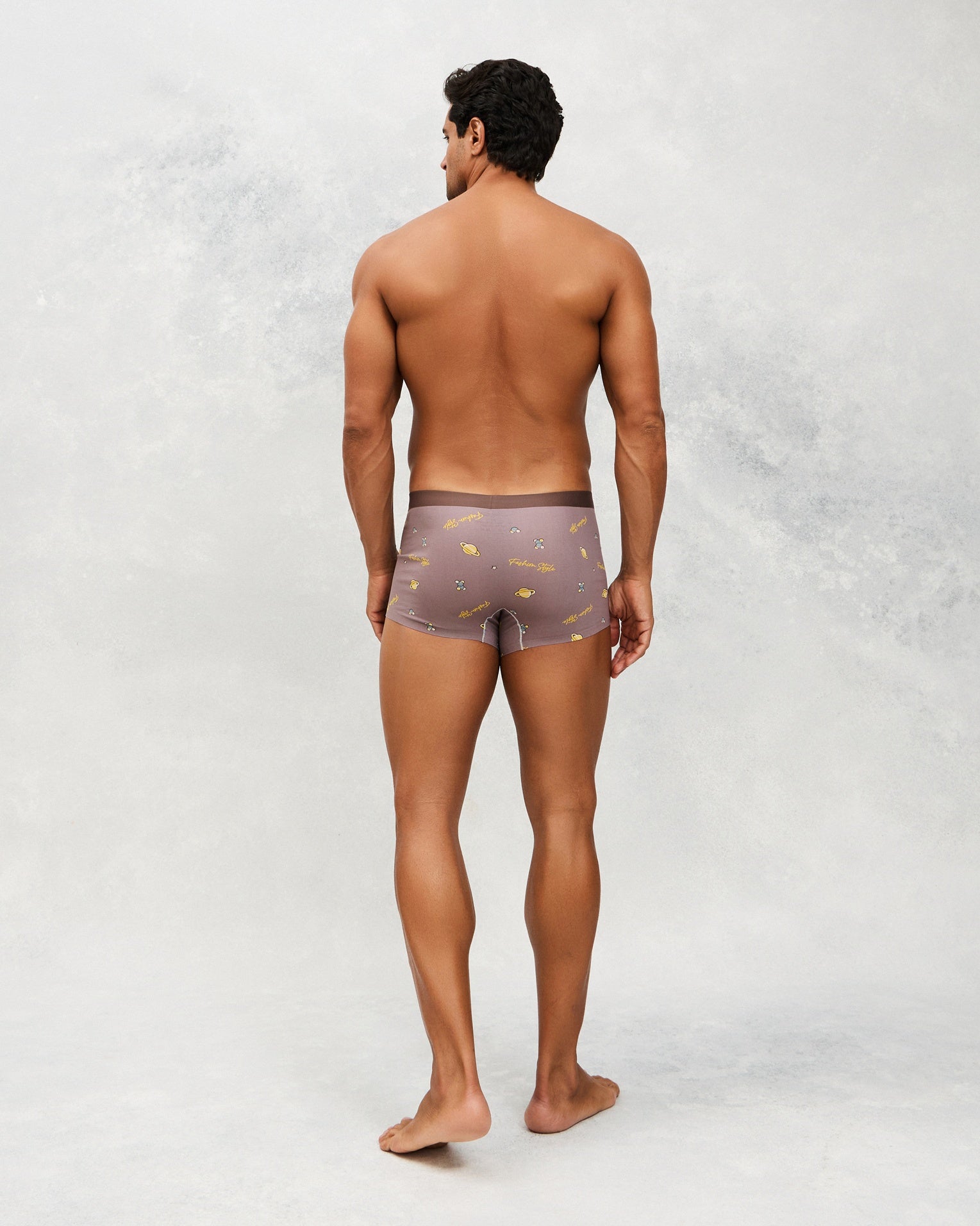 Back photo for a model wearing CottoSilk Galaxy Cotton Trunk in Brown with smooth finish and space print.