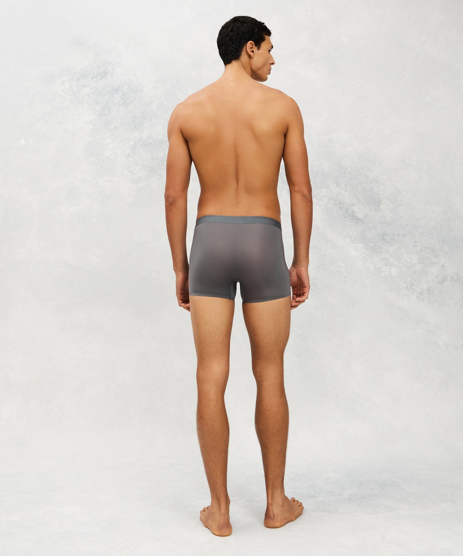 Back photo for a Model wearing Ultra Light Ice Tech Trunk in dark grey.